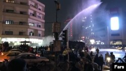 Pamje nga Teherani ku policia përpiqet t'i shpërndajë demonstruesit me topa uji