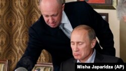 "Путиндин ашпозчусу" атыккан ишкер Евгений Пригожин (солдо) президент Владимир Путин менен. Сүрөт 2011-жылы тартылган.
