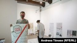 Adrian Buga, istoric de artă și curatorul expoziției „FAKE MAPS/HĂRȚI FALSE/FALSCHE KARTEN”, în timpul panotării expoziției de la Muzeul Hărților.