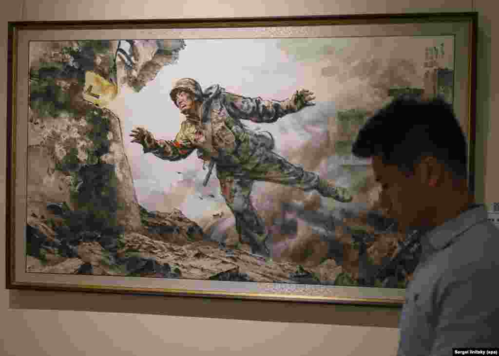 Полотно під назвою «Віддаючи безцінне життя» на виставці північнокорейського мистецтва в Москві. 8 жовтня 2025 року.Ця картина є однією з кількох на виставці із зображенням північнокорейських військ, які воювали на боці Росії проти ЗСУ