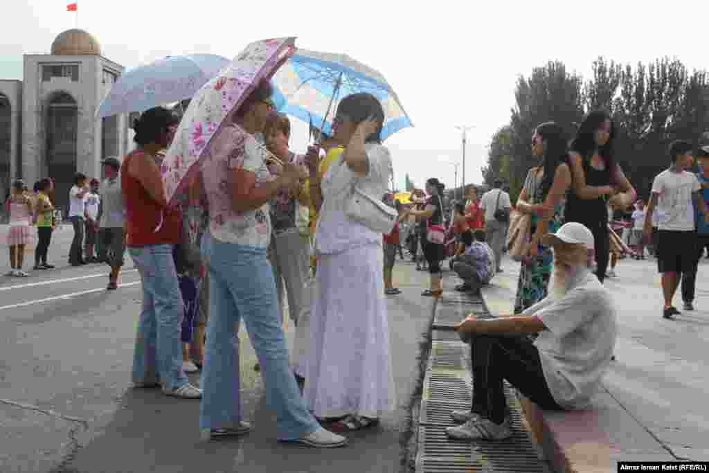 Родители и учителя ждали окончания репетиций под зонтами.