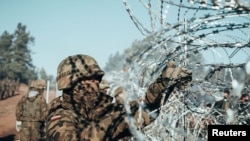 Польський солдат встановлює колючий дріт на кордоні між Польщею та Білоруссю поблизу Кузниці, Польща. Фото опубліковане Міністерством оборони Польщі 9 листопада 2021 року