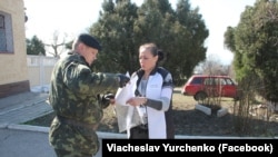 Журналістка Олена Юрченко передає заступнику командира військової частини А-0669 Олексію Нікіфорову слова підтримки українських морпіхів. Керч, Крим, березень 2014 року