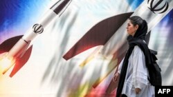 Тегерандын борбордук көчөсүндө бараткан аял. 15-апрель, 2024-жыл