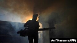 A worker fumigates to kill mosquito larvae to fight the spread of dengue fever in Karachi on September 20.