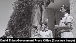 رضا صفی‌نیا، دیپلمات ایرانی، در سال ۱۹۵۰ هنگام ورود به اقامتگاه حییم وایزمن، اولین رئیس‌جمهور اسرائیل، که در نزدیکی تل‌آویو قرار داشت، به سربازان اسرائیلی سلام می‌دهد. <br><br>ایران در آن سال با فاصله گرفتن از همسایگان عرب خود، به طور غیررسمی کشور جدید اسرائیل را به رسمیت شناخت.