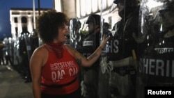 Žena ismijava pripadnike šerifovog odjela tokom protesta nakon što je policajac Rusten Sheskey pucao sedam puta u Jacoba Blakea, ispred sudskog vijeća okruga Kenosha Wisconsin, SAD, 24. augusta 2020. godine.