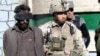 A U.S. soldier detains a suspected Afghan militant in January