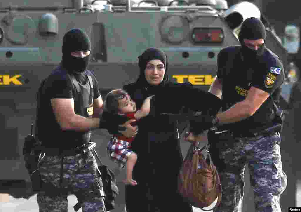 Два угорських спецпризначенця супроводжують мігрантів, - жінку та її дитину - в угорському Реске