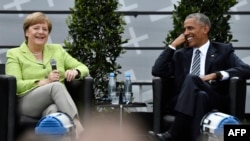 Former U.S. President Barack Obama and Chancellor Angela Merkel laugh as they attend a panel discussion at Berlin's Brandenburg Gate on May 25. 