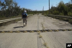 Спостерігач Спеціальної моніторингової місії ОБСЄ йде вздовж лінії фронту біля Луганська, 29 серпня 2016 року