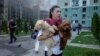 A Ukrainian woman with her dogs leaves the site of a Russian air strike on Kharkiv on July 24. 