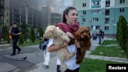 A Ukrainian woman with her dogs leaves the site of a Russian air strike on Kharkiv on July 24. 