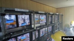 Radnici u zaštitnim odelima radi na mašinama za daljinsko upravljanje, nuklearna elektrana Fukušima Daići, 10. april 2011.