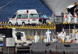 Медики швидкої допомоги та берегової охорони Японії в захисному спорядженні готуються до транспортування заражених пасажирів, які перебували на борту круїзного лайнера Diamond Princess, у порту Йокогама, 5 лютого 2020 року