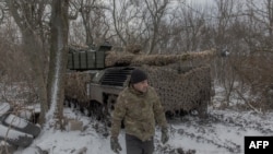 Un tanchist ucrainean din Brigada 68 alături de un tanc Leopard 1A5 într-o poziție din apropierea orașului Pokrovsk, în regiunea Donețk, Ucraina - 13 decembrie 2024.
