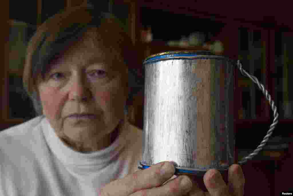 Zinaida Tarasevich, astăzi la 76 de ani, îține în mînă o cană primită de la mama ei, înainte de a muri. O “amintire” a ustensilelor folosite de părinții ei în anii petrecuți într-un lagăr din zona arctică a Rusiei. 