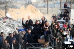 În imagine, palestinieni relocați revin în Raffah, în sudul Fâșiei Gaza, după intrarea în vigoare a acordului de încetare a focului.