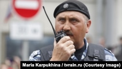 Колишній командир спецпідрозділу «Беркут» Сергій Кусюк у формі ОМОНу на мітингу в Москві, куди він втік від кримінального переслідування за злочини проти Майдану