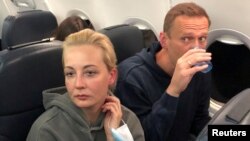 Юлия и Алексей Навални в самолета на път от Берлин за Москва. През август руският опозиционер беше отровен с Новичок на руска територия и излекуван в Германия. Той се върна в страната си на 17 януари и беше арестуван още на летището с аргумента, че е нарушил стара условна присъда, която ще трябва да излежи ефективно.