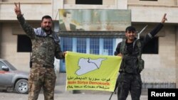 Membri ai formațiunii conduse de kurzi Forțele Democratice Siriene (SDF) cu steagul lor la Deir al-Zor, în estul Siriei, la 7 decembrie 2024.