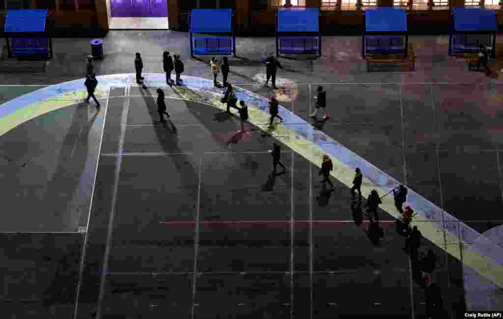 Ljudi čekaju u redu na igralištu pred vratima biračkog mjesta u osnovnoj školi u okrugu Manhattan u New Yorku, 3. studenog 2020.