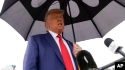 Ish-presidenti amerikan, Donald Trump, duke folur para gazetarëve, përpara se të hipte në aeroplanin e tij, në aeroportin "Ronald Reagan", më 3 gusht, pas paraqitjes në gjyq në Uashington për t'u deklaruar rreth akuzave për komplot për përmbysjen e humbjes në zgjedhje më 2020.