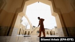 Мужчина моет полы в мечети перед священным месяцем Рамадан во время пандемии коронавируса в Пешаваре. 12 апреля 2021 года.