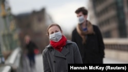 Люди в захисних масках на вулицях Лондона