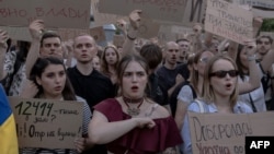 Protesters hold placards during a demonstration against a law that removes the independence of two key anti-corruption bodies, in downtown Kyiv on July 23.