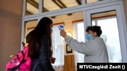 Ellenőrzik egy diák hőmérsékletét a bagaméri iskolában 2020. szeptember 29-én