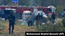 akistani officials collect pieces of an F-16 plane that crashed in Islamabad on March 11.