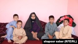 A Afghan women with her family in Herat Province after they are deported from Iran (file photo)