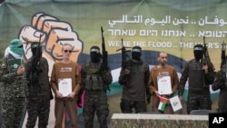 Cei trei ostatici au fost îmbrăcați în haine kaki de către Hamas. Ei au fost obligați să pozeze și certificatele primite. 