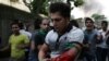 Iranians react as a protestor is wounded at the opposition rally in Tehran on June 15