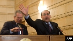 Iraqi Prime Minister Nuri al-Maliki tries to block U.S. President George W. Bush after an Iraqi man threw his shoes at Bush.