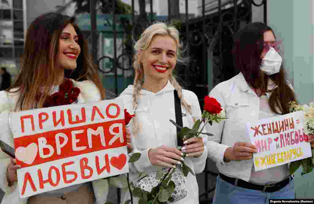 Femei participând la un miting la Moscova, pe 15 august, pentru a-și manifesta solidaritatea cu protestatarii din Belarus. Pe bannerul din stânga scrie: &bdquo;A venit vremea iubirii&rdquo;. Pe cel din dreapta scrie : &bdquo;Femeile sunt pace și dragoste. Trăiască Belarus.&quot;