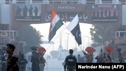 Pakistani Rangers (in black) and Indian Border Security Force personnel take part in the daily retreat ceremony at the India-Pakistan Wagah Border Post in Kashmir on December 18.