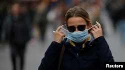 Maszkot viselő nő megy az utcán Kijevben, Ukrajna, 2020. október 22.-én.