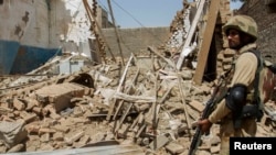 FILE: A Pakistani soldier stands near the debris of a house which was destroyed during a military operation in North Waziristan's headquarter Miran Shah in July 2014.