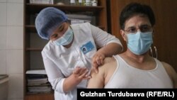 Кытайдын "Sinopharm" вакцинасын алып жаткан киши.