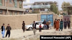 Residents gather near the site of a suicide attack on prison employees' vehicle in Kabul on October 31.