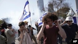 Demonstranti u Izraelu reaguju na šok bombe koje ispaljuje policija, Tel Aviv, Izrael, 1. mart 2023.