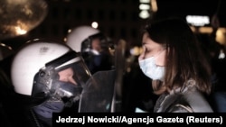 Az abortusztörvény ellen tiltakozó nő néz farkasszemet egy lengyel rendőrrel az október 26-i tüntetésen, Varsóban.