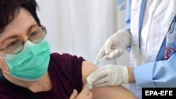 Një grua duke u vaksinuar kundër koronavirusit, në një qendër vaksinimi në Shkup. 31 mars, 2021. 