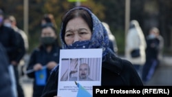 Женщина держит плакат с требованием освободить политзаключенного Арона Атабека на митинге Алматы. 31 октября 2020 года.