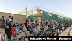 Emberek várakoznak az afganisztáni Kabul repülőtere előtt 2021. augusztus 25-én