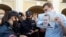 Policajka legitimiše muškarca koji drži plakatu sa likom Aljekseja Navaljnija, opozicionog lidera koji je u bolnici u sibirskom gradu Omsku, na protestu u Sankt Petersburgu. 20. avgust 2020.
