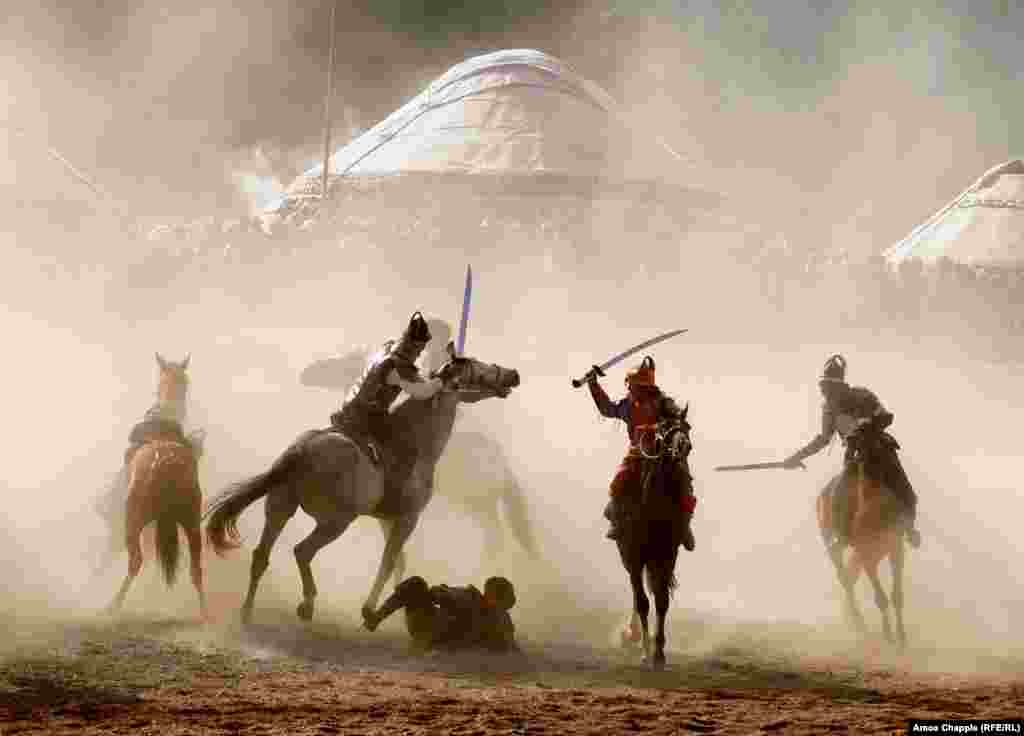 Horsemen fight through clouds of dust during a simulated battle as part of the kickoff.