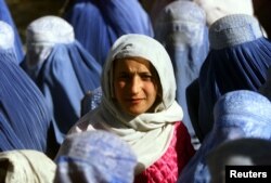 یک زن جوان افغان، در ۱۴ نوامبر ۲۰۰۱، چندی پس از پنج سال اجبار زنان در دوره طالبان به برقع‌پوشی، چهره خود را در برابر دوربین نشان داده است.